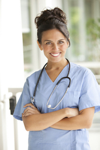 Picture of a female Nurse crossing her arms and smiling. She has a stethoscope around her neck.