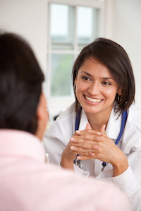 Picture of a female Physician smiling at a male patient.